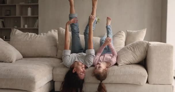 Joyeuse maman et petite fille couchées à l'envers sur le canapé — Video