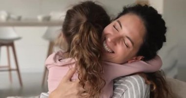 Güzel, genç bir anneye yakın, küçük bir kıza sarılıyor.