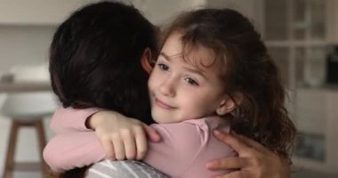 Sevimli küçük bir kız. Genç ve sevgi dolu bir anneye sarılıyor.