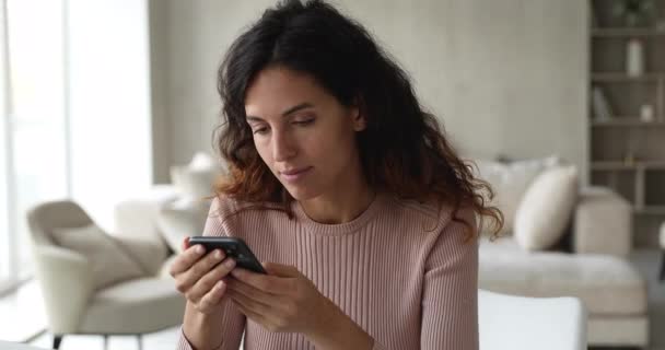Kvinnliga sitta inomhus innehav smartphone köpa e tjänster på internet — Stockvideo