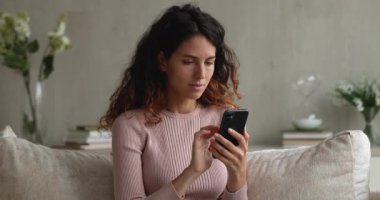 Akıllı telefon tutan kadın e-postaları kontrol ediyor. Harika haberler okuyor. Başarıyı kutluyor.