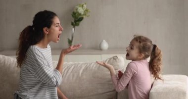 Kadın konuşma terapisti küçük kıza sesli telaffuz öğretiyor.