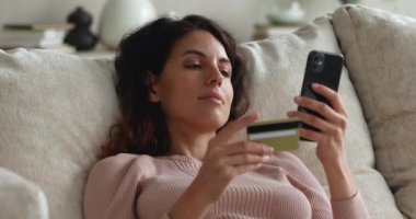 İnternet üzerinden kredi kartı ve akıllı telefon kullanan bir kadın