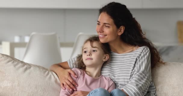 Mama przytulanie mała córka siedzieć na kanapie spędzać czas razem — Wideo stockowe