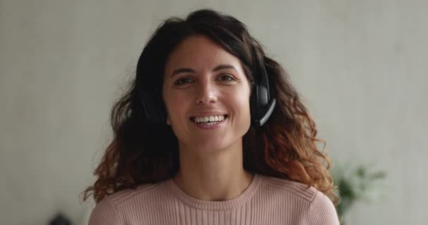 Jovens fones de ouvido desgaste feminino assiste a entrevista de emprego remotamente através de videoconferência — Vídeo de Stock