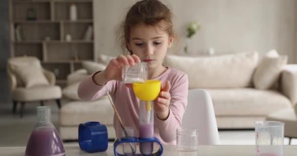 Küçük kız şişelerde sıvı karıştırıyor. Evde kimya seti çalıyor. — Stok video