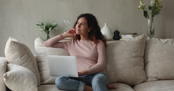 Γαλήνια ικανοποιημένη νεαρή γυναίκα χαλαρώνοντας στον καναπέ με φορητό υπολογιστή — Αρχείο Βίντεο
