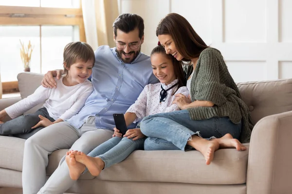 Çocuklu mutlu bir aile evde cep telefonu kullanıyor. — Stok fotoğraf