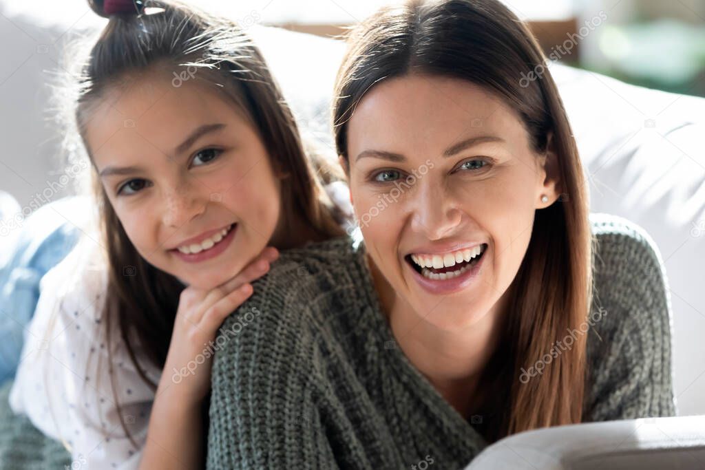 Portrait of smiling mom and daughter relax together