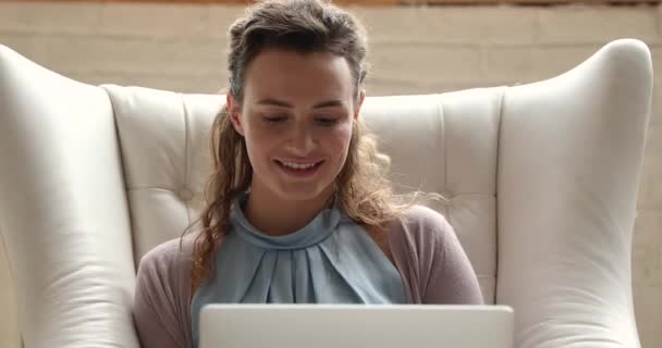 Feliz joven mujer caucásica utilizando la computadora, relajarse en la silla. — Vídeos de Stock