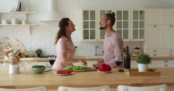 Energetic overjoyed young loving family couple dancing in kitchen. — Stock Video