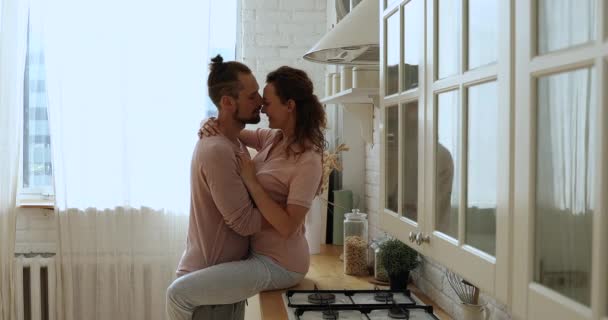 Romantic beautiful young couple kissing passionately in kitchen. — Stock Video