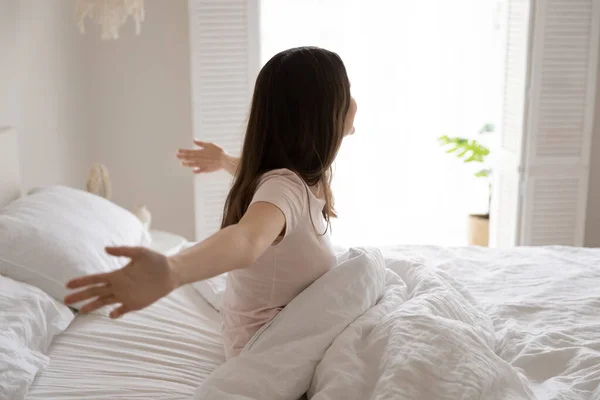 Gadis remaja terbangun di tempat tidur, meregangkan tangan setelah tidur nyenyak — Stok Foto