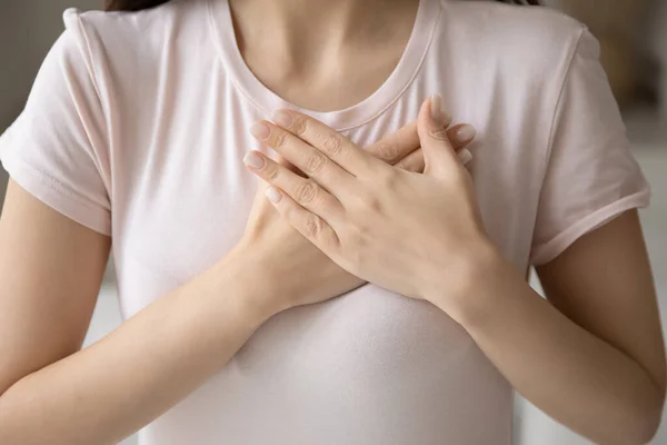 Tacksam ung kvinna tillämpa händerna på bröstet, uttrycker kärlek — Stockfoto