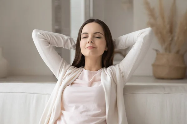 Peaceful girl with closed eyes resting on comfortable couch — Stock Photo, Image