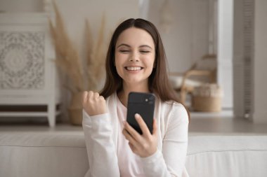 Cep telefonlu heyecanlı milenyum kızı haberlere seviniyor