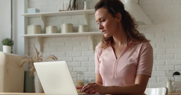 Молодая белая женщина, работающая дома за компьютером. — стоковое видео