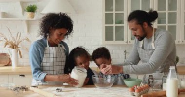Küçük çocuklara yemek yapmayı öğreten Afrikalı ebeveynler..