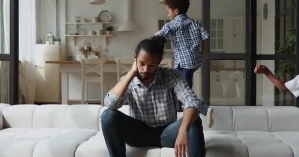 Ayah muda yang tidak bahagia african jengkel oleh anak-anak berisik. — Stok Video