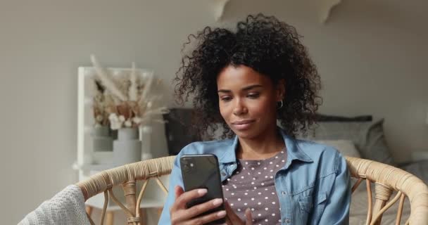 Улыбающаяся молодая красивая африканская американка с помощью смартфона. — стоковое видео