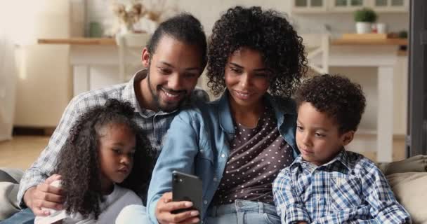 Mutlu Afro-Amerikan çifti çocuklarla akıllı telefon kullanıyor.. — Stok video