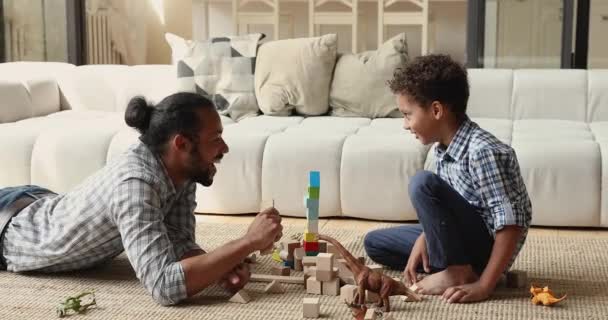 Щаслива афроамериканська маленька дитина грає з батьком вдома . — стокове відео