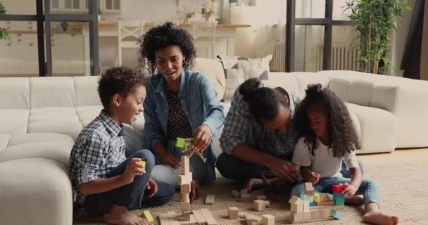 Jóvenes de etnia africana padres jugando juguetes con niños. — Vídeo de stock