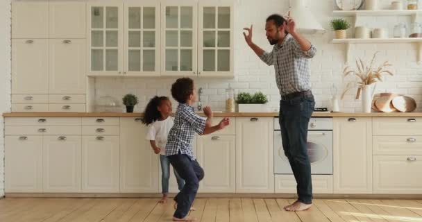 Petits enfants africains joyeux répétant des mouvements drôles après père. — Video