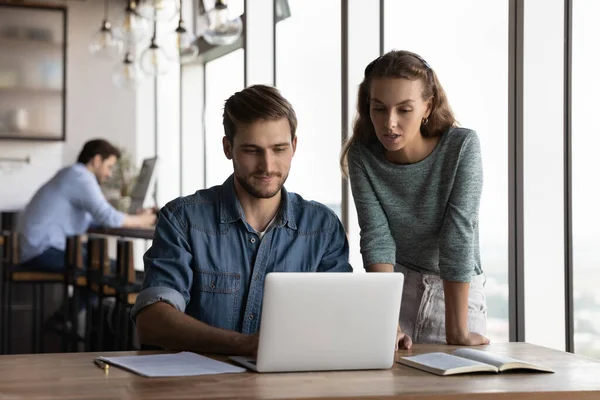 Les jeunes employés coopèrent en utilisant un ordinateur portable au bureau — Photo