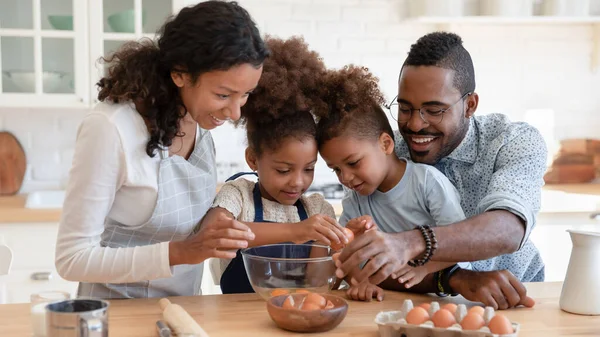 快乐的非裔美国父母和孩子们一起在厨房里烘焙 — 图库照片