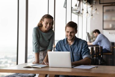Mutlu iş arkadaşları iş yerindeki bilgisayarda beyin fırtınası yapıyor