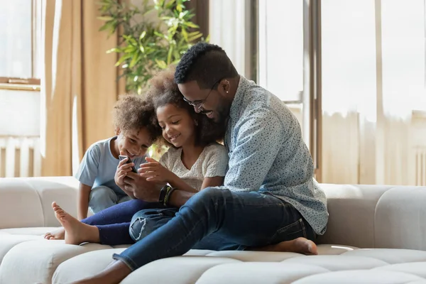 Glücklicher Papa hilft süßen Kindern, App auf Smartphone zu nutzen — Stockfoto