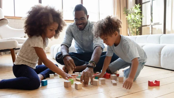 Glücklicher Millennial-Papa genießt Lernspielzeit mit Geschwistern im Vorschulalter — Stockfoto