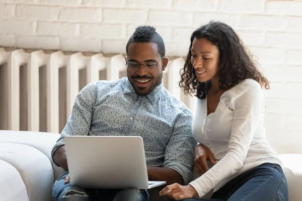 Feliz pareja de raza mixta negro utilizando el ordenador portátil en casa — Foto de Stock