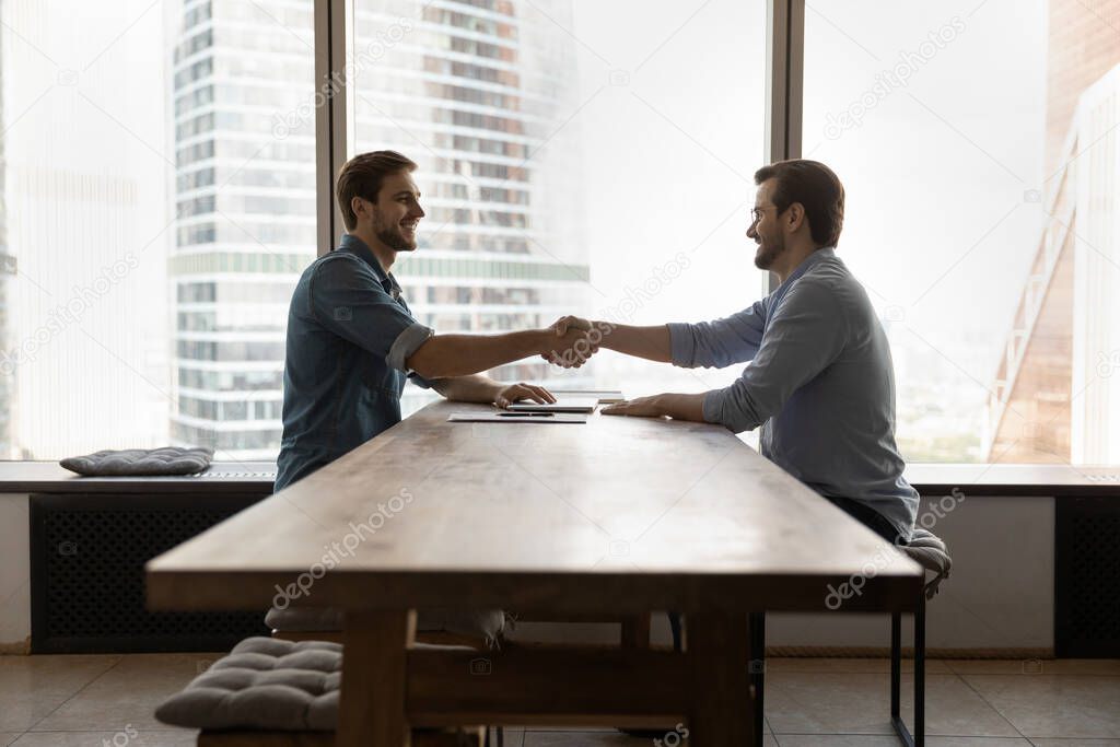 Smiling business partners handshake at office meeting