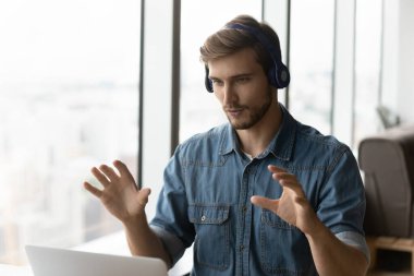 Kulaklık takan erkek çalışanın webcam zoom çağrısı var.