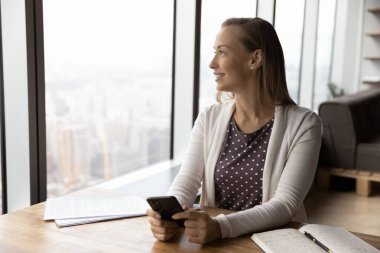 Mutlu kadın cep telefonuyla fırsatlar yaratıyor.