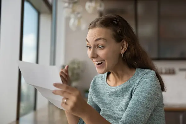 Spännande ung kvinna får goda nyheter i pappersbrev — Stockfoto