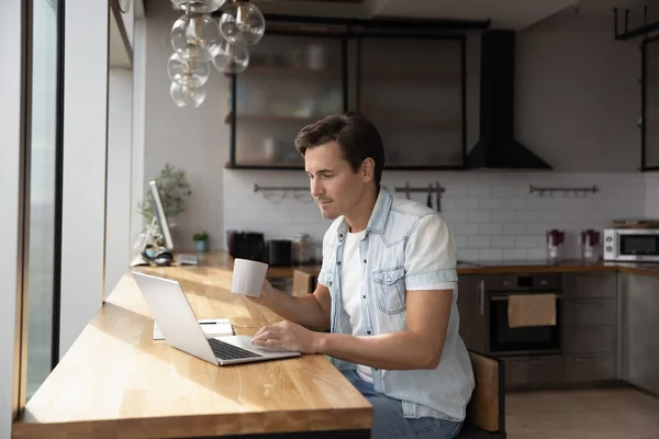 白人男子坐在家里厨房用笔记本电脑 — 图库照片