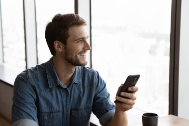 Gülümseyen adam cep telefonunu kullan. Uzaktan düşün.