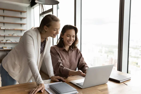 Gülümseyen kadın çalışanlar dizüstü bilgisayarla çalışırken beyin fırtınası yapıyorlar. — Stok fotoğraf