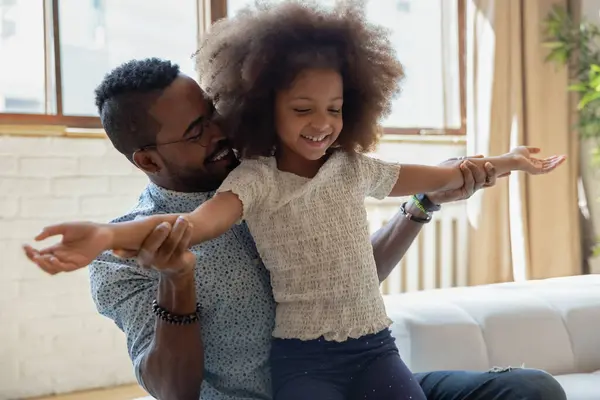 Feliz pai afro-americano ensinando a filha pré-escolar biracial — Fotografia de Stock
