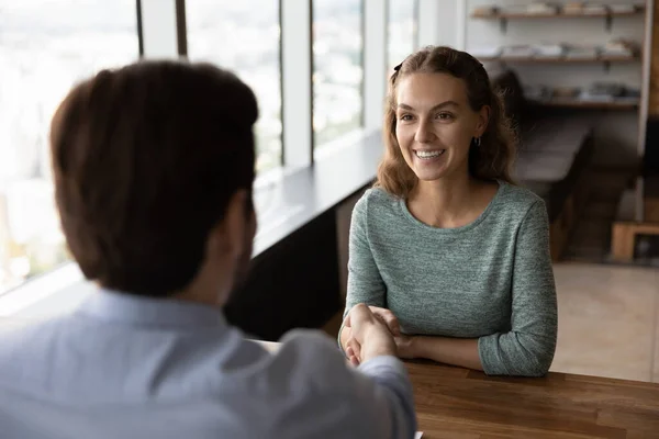 Glimlachende vrouwelijke werknemer handdruk zakenpartner bij vergadering — Stockfoto