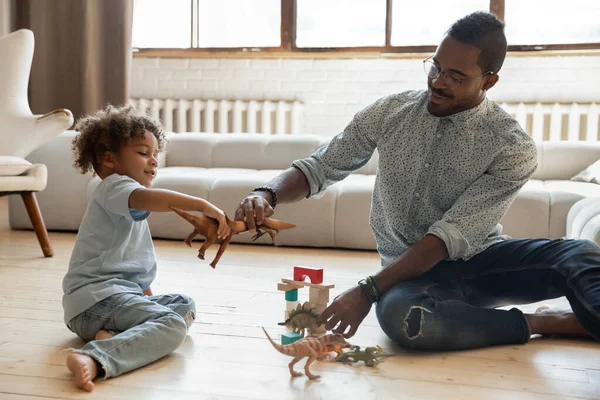 Glücklicher Vater und Kleinkind-Sohn schaffen Dinosaurier-Schlacht — Stockfoto