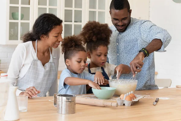 Glückliches Elternpaar und Kinder backen gemeinsam hausgemachten Nachtisch — Stockfoto