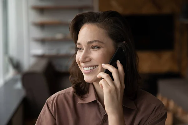 Smiling woman talk on smartphone gadget with client