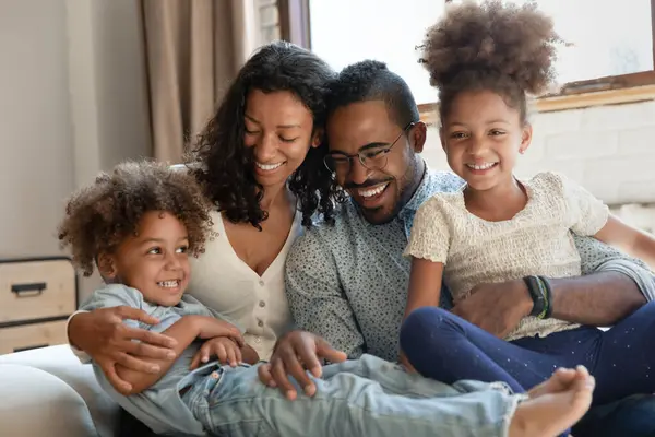 Glückliche afroamerikanische Eltern und zwei aufgeregte Kinder, die Spaß haben — Stockfoto