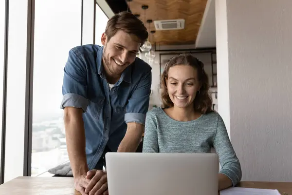 Mutlu erkek ve kadın meslektaşlar laptopta işbirliği yapıyor. — Stok fotoğraf