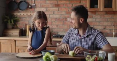 Küçük kızıyla yemek pişiren şefkatli bir baba..