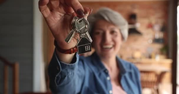 Ενθουσιασμένη ειλικρινής μεσήλικη γυναίκα που δείχνει τα κλειδιά της κάμερας. — Αρχείο Βίντεο